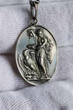 Hebe was the goddess of youth and had the ability to restore vitality to any being. She also served the gods with ambrosia and nectar, divine delicacies, which granted immortality. On this pendant, Hebe is offering nectar to Zeus in his eagle form. Approx. Dimensions : 30mm x 24mm Approx. Weight: 11g Each Olithica pendant is handcrafted in our Los Angeles studio. We use exclusively 925 sterling silver for all our pieces. The Goddess, Sterling Silver Pendants, Silver Pendant, Mens Jewelry, Angeles, 925 Sterling Silver, Sterling Silver, Pendant