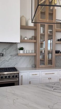 a kitchen with marble counter tops and wooden cabinets in the center, along with white cupboards