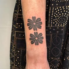 a black and white flower tattoo on the wrist