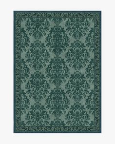 a green rug with an ornate design on the front and back side, in dark blue