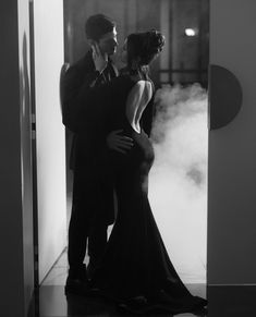 a man and woman standing in front of an open door with steam coming from them