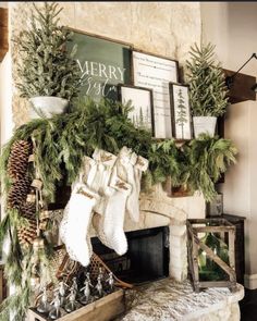 a mantel decorated with stockings, pine cones and evergreens for the holiday season