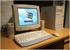 a desktop computer sitting on top of a wooden desk next to a keyboard and mouse