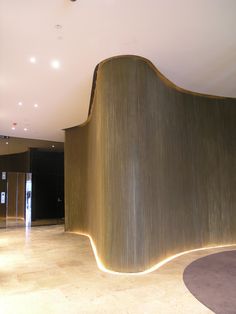 a curved wall in the middle of a large room with lights on it's sides