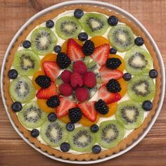 a pie topped with fruit on top of a wooden table