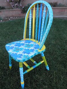 a blue and yellow chair sitting in the grass