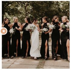 a group of women standing next to each other wearing black dresses and holding bouquets