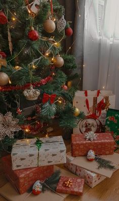 presents under the christmas tree in front of a window