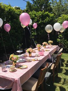 a long table with balloons and plates on it