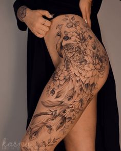 a woman is showing off her thigh with flowers and birds tattoo on it's side