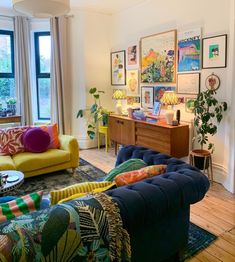 a living room filled with lots of furniture and decor on top of a hard wood floor