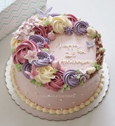 a birthday cake decorated with flowers and butterflies