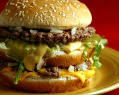 a cheeseburger with lettuce and other toppings on a yellow plate