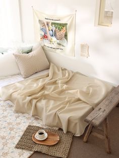 a bed covered in a blanket next to a wooden bench