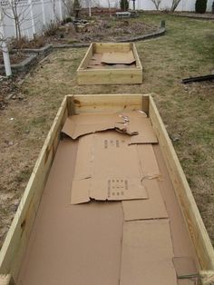 two wooden boxes sitting in the middle of a yard