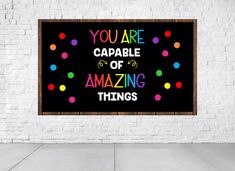 a sign that says you are capable of amazing things hanging on a white brick wall