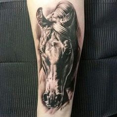 a black and white horse tattoo on the right leg, with its head turned to the side