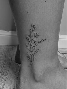 a black and white photo of a flower on the ankle