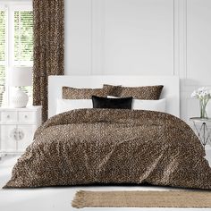 a leopard print comforter set on a white bed