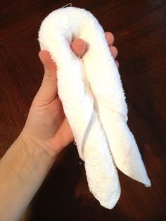 a hand holding a white towel on top of a wooden table