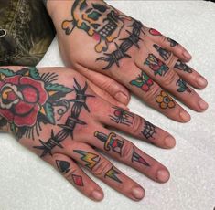 two hands with tattoos on them sitting next to each other