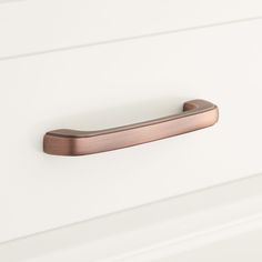 a close up of a door handle on a white cabinet