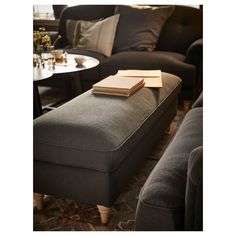 a living room filled with furniture and a book on the ottoman