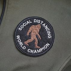 a badge on the back of a jacket that says social distancing world champion