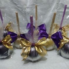 three chocolate candies wrapped in purple and gold ribbon