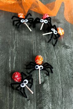 spider lollipops are on sticks with googly eyes and orange candies