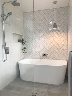 a white bath tub sitting next to a walk in shower