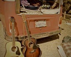 two guitars are sitting in front of an orange van