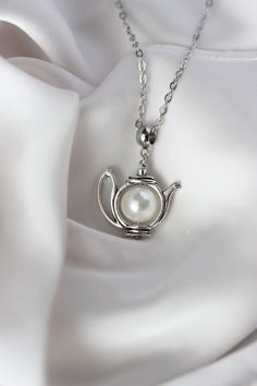 This feminine pretty necklace is made of silver tone teapot charm with finest quality European crystal white pearl bead inside and silver tone chain. Finest quality European crystal pearls which are also known as crystal pearls or glass pearls are high quality imitation pearls. What makes them so popular for jewellery making is their unique design that gives them the look and feel of a real pearl. With European crystal  pearls the coating is always perfect, they are always perfectly formed and t Teapot Jewelry, Teapot Necklace, Pretty Necklace, Tea Lovers Gift, Gift Tea, Crystal White, Tea Lovers, Pretty Necklaces, Necklace White