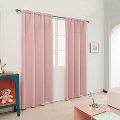 a living room with pink curtains and a teddy bear on the end table in front of it