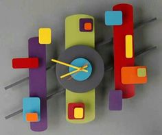 a multicolored wall clock with sticks sticking out of it's face and hands