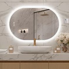 a bathroom with marble counter tops and a round mirror on the wall above the sink