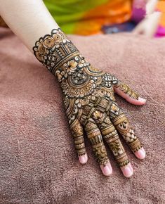 a woman's hand decorated with henna and intricate designs on her hands,