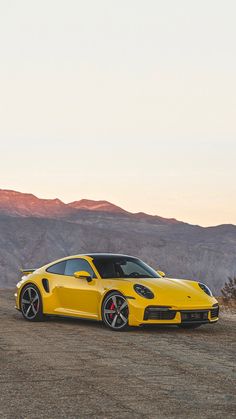 a yellow sports car parked in the desert