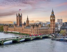 the big ben clock tower towering over the city of london in england, with a bridge leading to it