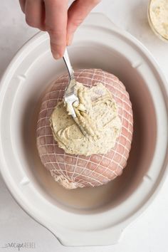 a person is dipping something into a bowl