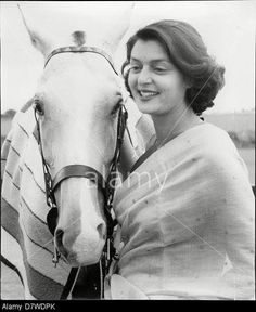 black and white photograph of a woman sitting next to a horse