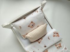 a baby crib with teddy bears and checkered pillow in the bottom half, on top of it