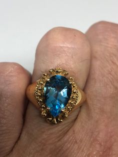 Huge great color blue topaz stone setting is handcrafted in gold finished 925 sterling silver Size 6 Can be sized, my jeweler charges $10-$20 Please ask for a quote? All rings are shipped free in the US in a nice gift box. Check out our over a THOUSAND great reviews Engraving is $4 per letter and is not always perfect depending on the piece. It can take a few days if the jeweler is busy. This is payable to Paypal Judithsltd@gmail.com Formal Pear-shaped Topaz Ring Fine Jewelry, Fine Jewelry Blue Topaz Teardrop Rings, Unique Yellow Gold Topaz Ring For Formal Occasions, Pear-shaped Topaz Jewelry For Anniversary, Formal Pear-shaped Topaz Ring With Prong Setting, Blue Topaz Teardrop Ring Fine Jewelry, Formal Topaz Crystal Ring With Prong Setting, Fine Jewelry Pear-shaped Topaz Ring, Pear-shaped Topaz Jewelry With Accent Stones