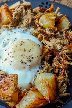 a blue plate topped with fried potatoes and an egg on top of hashbrowns