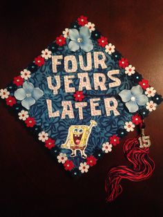 a decorated graduation cap with the words four years later written in blue and red flowers