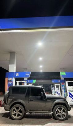 a black jeep parked in front of a gas station