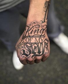 a man's hand with the words king of my soul tattooed on his left arm