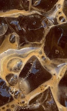 some ice and brown liquid on top of each other