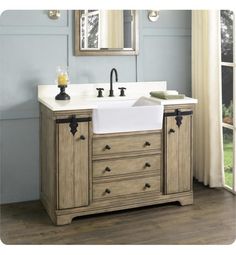 a bathroom sink sitting under a mirror next to a wooden cabinet with drawers and two faucets