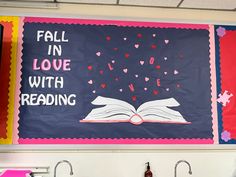 a bulletin board that says fall in love with reading and hearts on the book cover